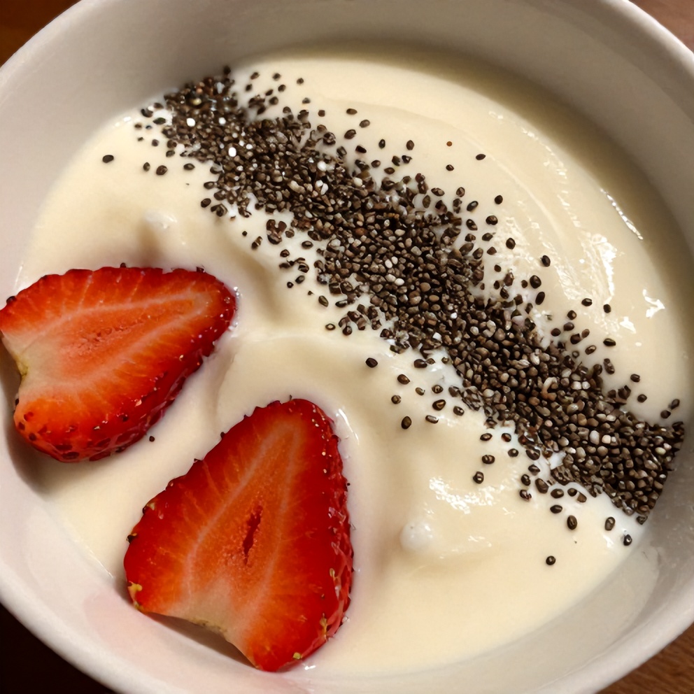 Strawberry yogurt parfait in a white bowl with a sprinkle of chia seeds
